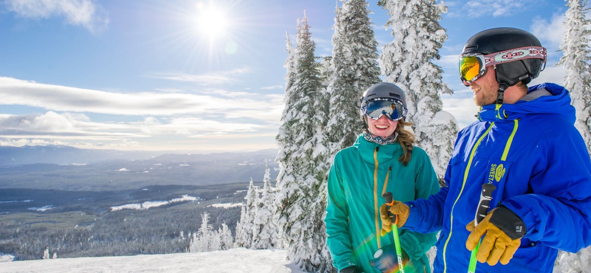 Two skiers enjoying a laugh at the top of a run at Big White Ski Resort