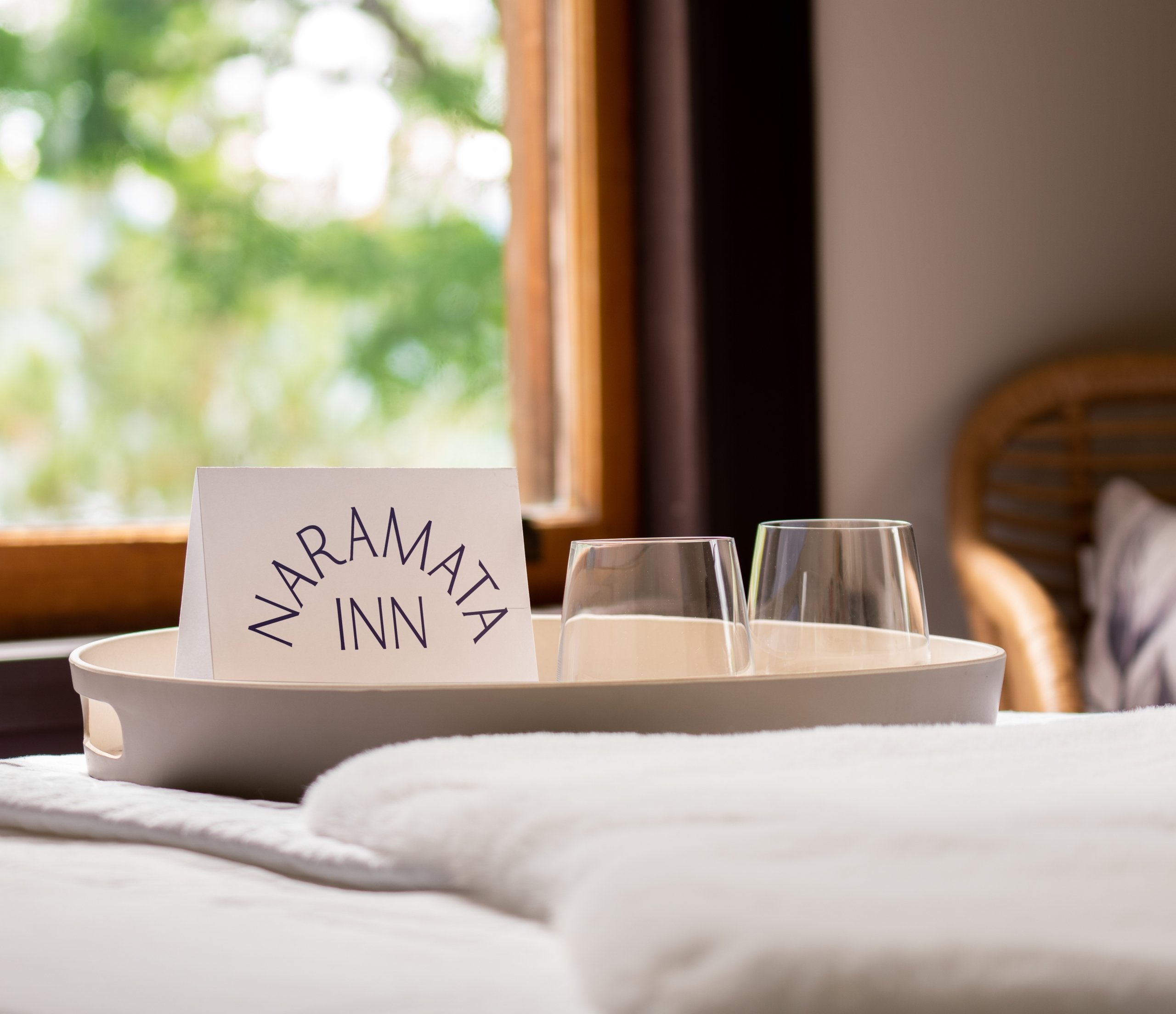 A close up of a tray on a bed with a notecard that reads,
