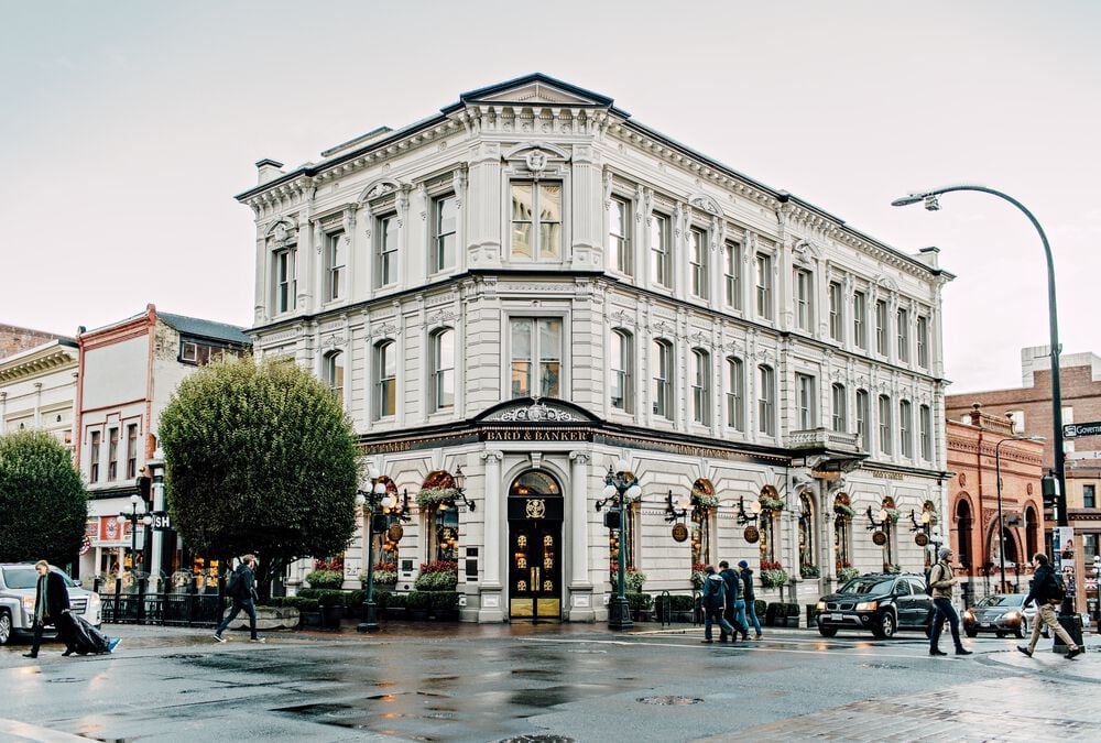 A view of the outside of a three-story white stone building.