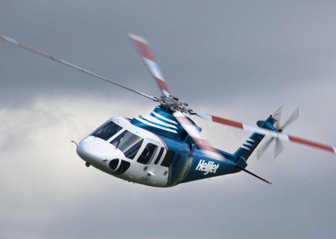 Un helicóptero de Helijet International vuela contra un cielo nublado.