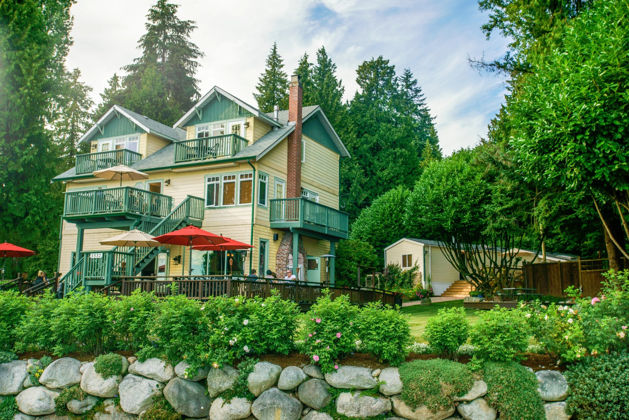 Exterior view of Bonniebrook Lodge, surrounded by evergreen trees and a rock wall with green shrubbery