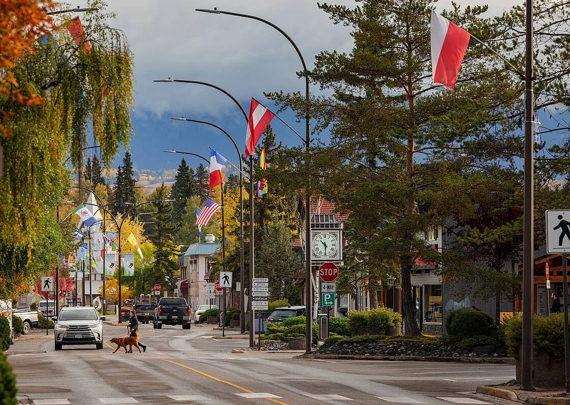 Downtown Smithers in the fall. A person crosses the street with their dog.