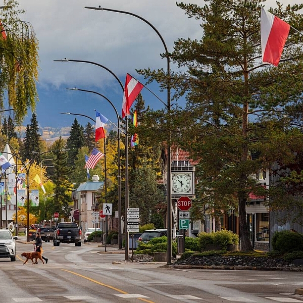 El centro de Smithers en otoño. Una persona cruza la calle con su perro.