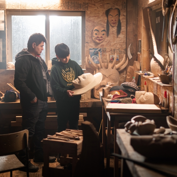 Nisga'a carver Calvin McNeil looks at First Nations artwork in a carving shed with his son, Jacob.