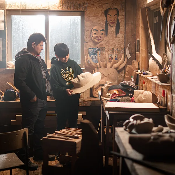 Nisga'a carver Calvin McNeil looks at First Nations artwork in a carving shed with his son, Jacob.