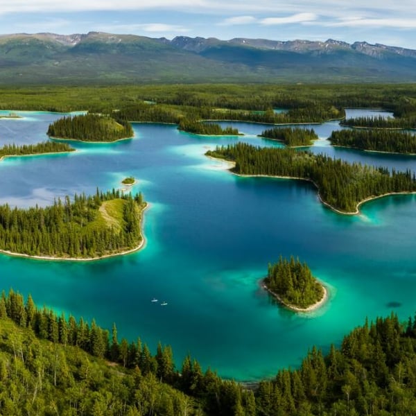 Unos remeros se deslizan por un lago turquesa salpicado de islas arboladas.