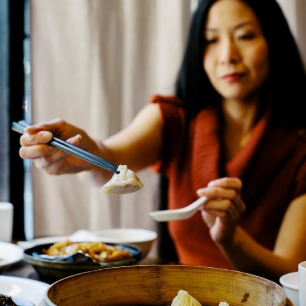 A woman lifts a dumpling out of a basket with chopsticks at a restaurant in the Golden Village district in Richmond.