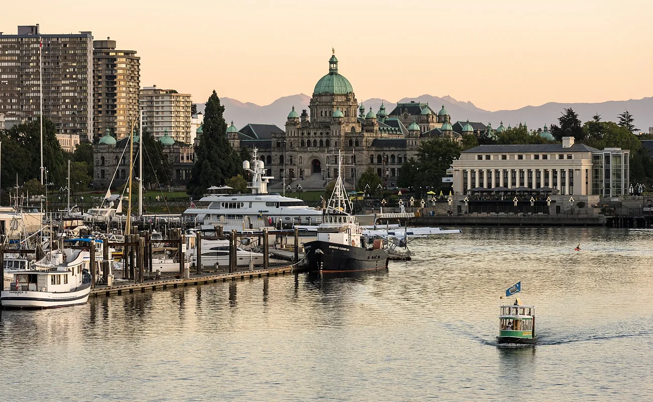 Victoria's Inner Harbour as a boat taxi cruises along the water and the sunsets