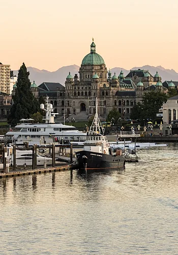 Victoria's Inner Harbour as a boat taxi cruises along the water and the sunsets