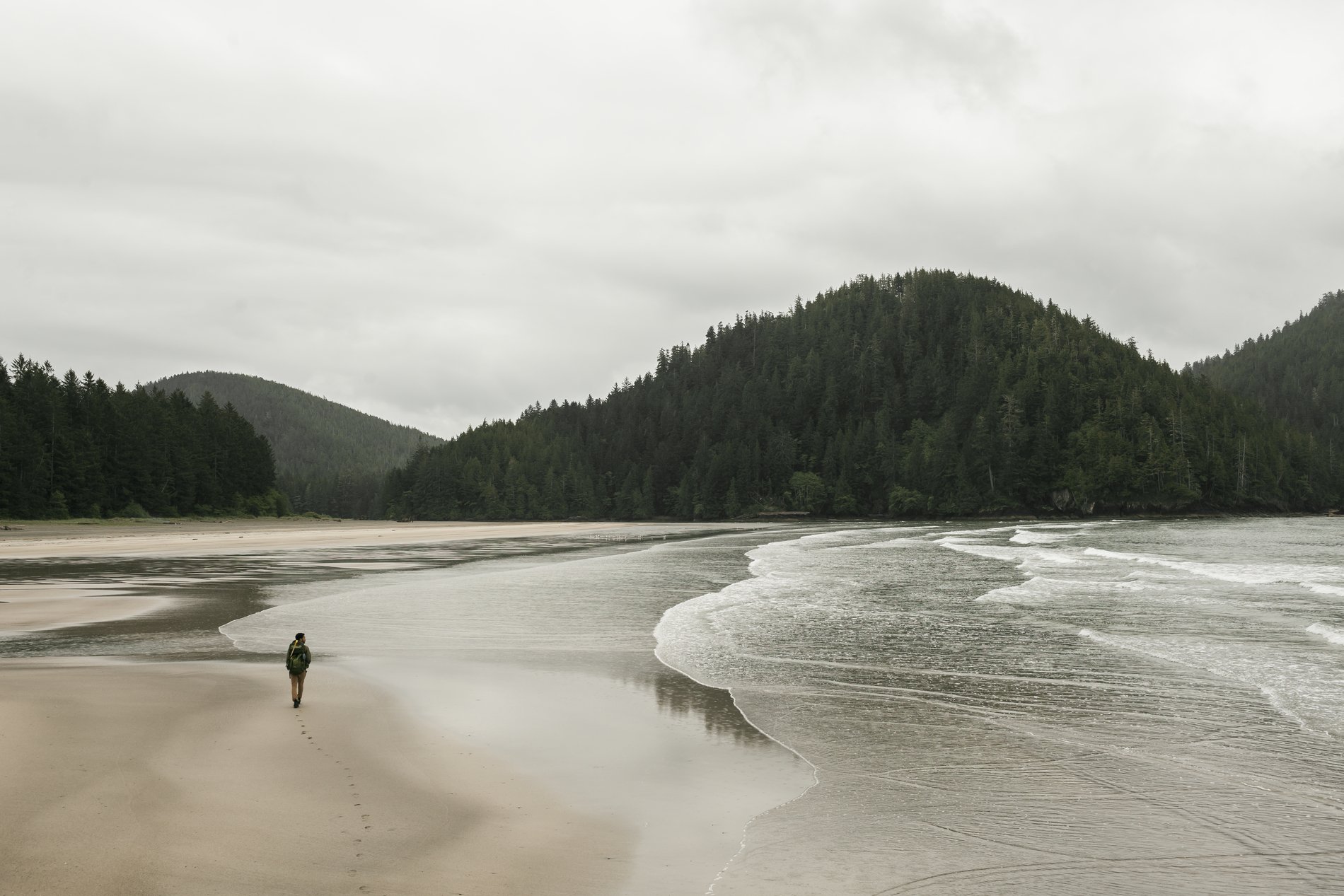 A person walks along the beach in San Josef Bay in Cape Scott Provincial Park