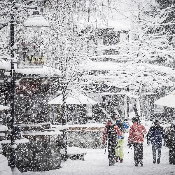 Un nevado pueblo de Whistler con gente caminando por las calles peatonales.