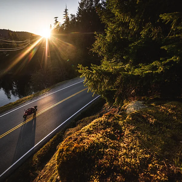 A motorcycle out for a sunset ride past Ruby Lake. There are no other vehicles on the road.