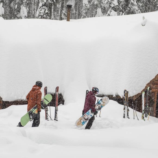 Snowboarders heading to a private cabin at Red Mountain Resort.