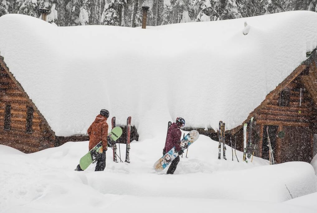 Snowboarders heading to a private cabin at Red Mountain Resort.