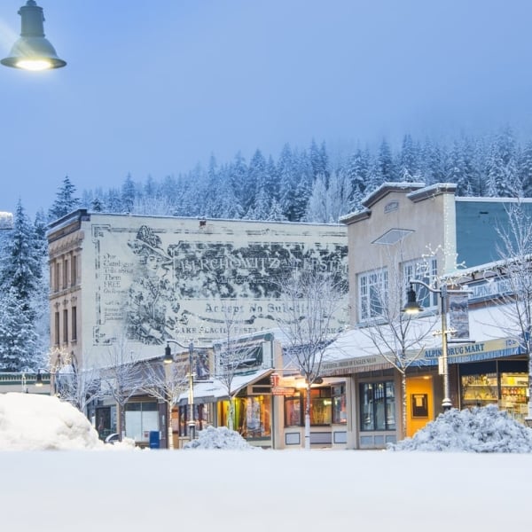 View of a main street lined with heritage buildings covered in snow as more snow falls