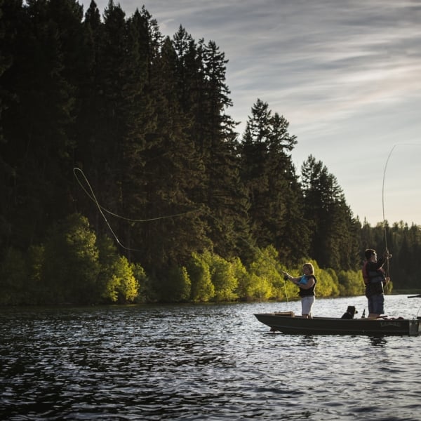 Two people stand in a small boat Fly-fishing in Fawn Lake