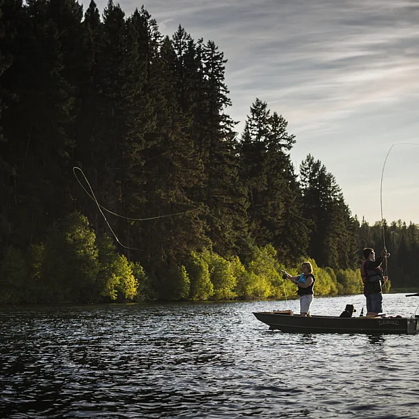 Two people stand in a small boat Fly-fishing in Fawn Lake