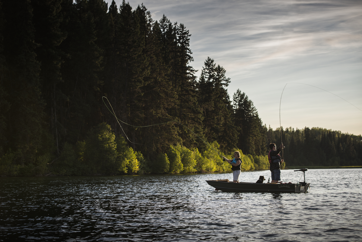 Two people stand in a small boat Fly-fishing in Fawn Lake
