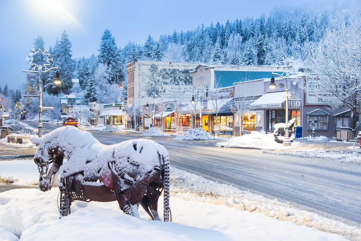 Downtown Rossland with snow-covered historic buidings and an iron horse statue.