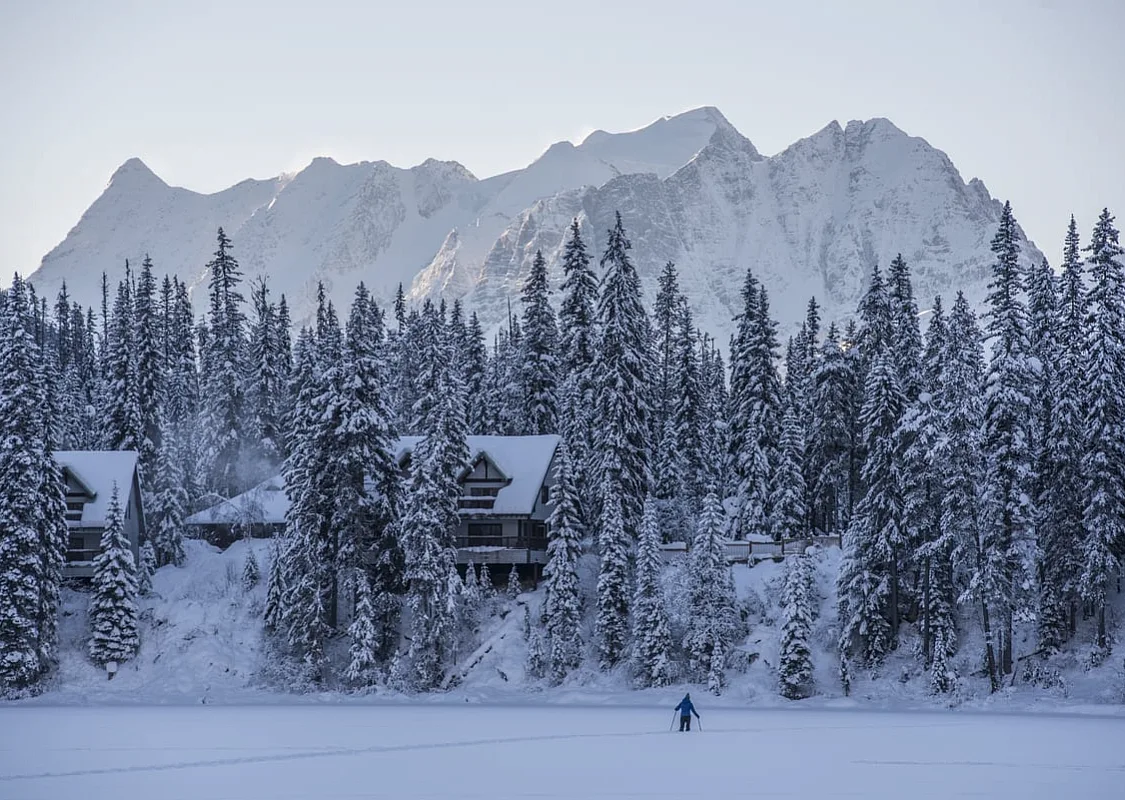 Ein*e Schneeschuhwanderer*in überquert den Emerald Lake in Richtung Emerald Lake Lodge im Yoho National Park | Keri Medig.