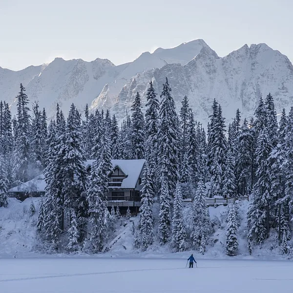 Ein*e Schneeschuhwanderer*in überquert den Emerald Lake in Richtung Emerald Lake Lodge im Yoho National Park | Keri Medig.
