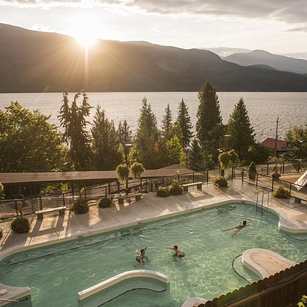 Bathers enjoy simming at Ainsworth Hot Springs with a view of Kootenay Lake