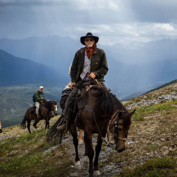 A horseback guide leads a group through vast countryside.
