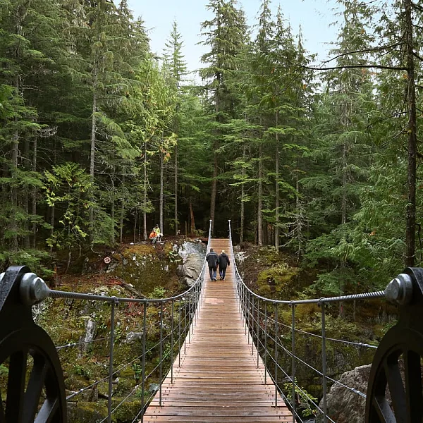 Zwei Personen gehen über eine Hängebrücke in Whistler.