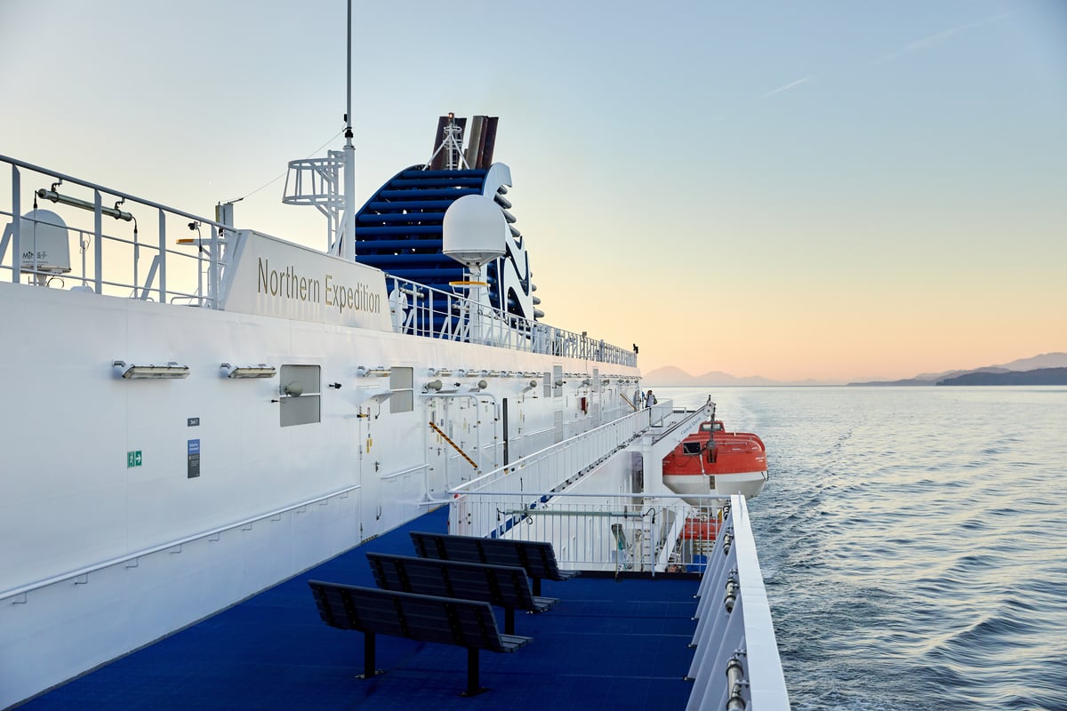 A close up of the side of a BC Ferry boat on the ocean as the sun sets. The words, 