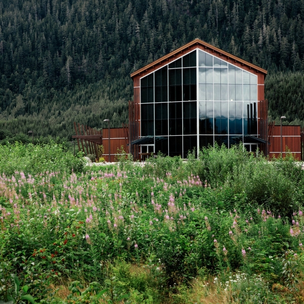 The Nisga'a Museum in Village of Laxgalts'ap, Nisga'a Nation is a beautifully designed wooden building with large floor to ceiling windows, perched in a lush forest.