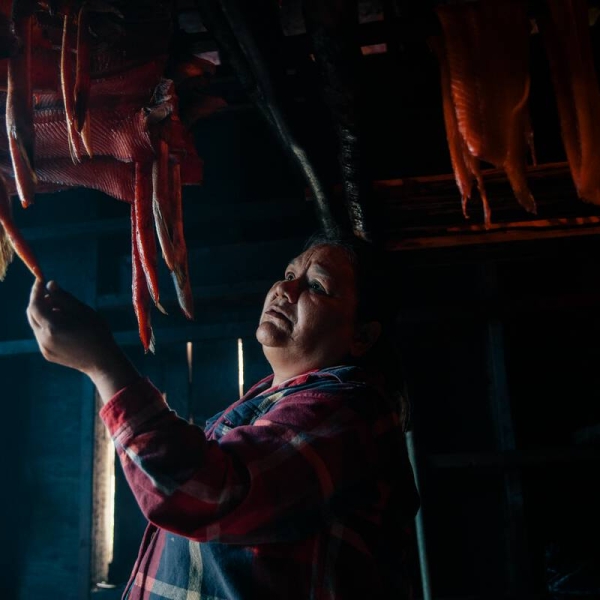 An Indigenous person from the Nisga'a Nationsmoking salmon in a smoke house in the village of Gingolx.