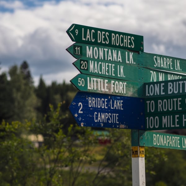 A post with multiple direction signs to various lakes