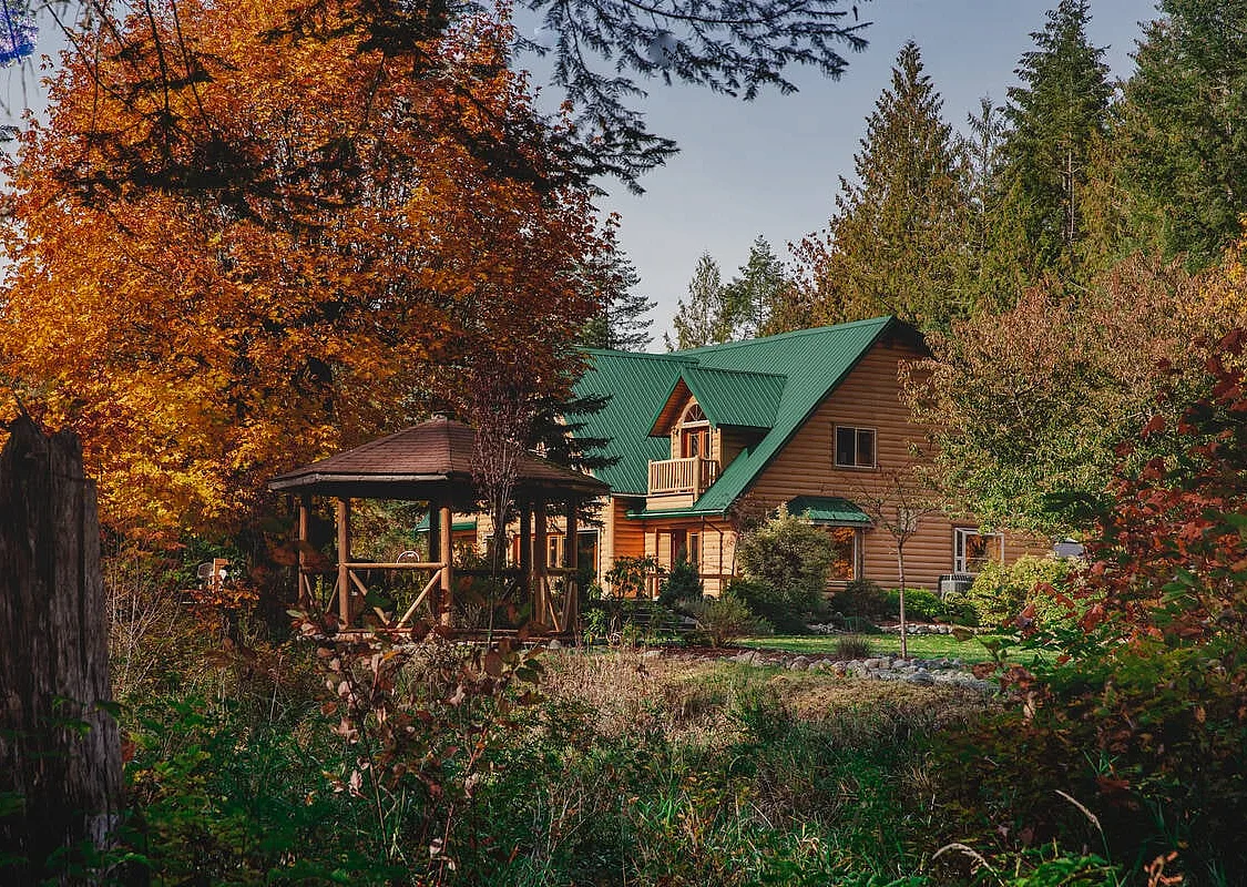 Cowichan River Lodge among trees with fall leaves in Lake Cowichan