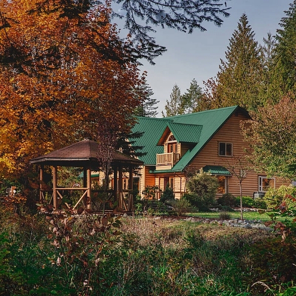Cowichan River Lodge among trees with fall leaves in Lake Cowichan