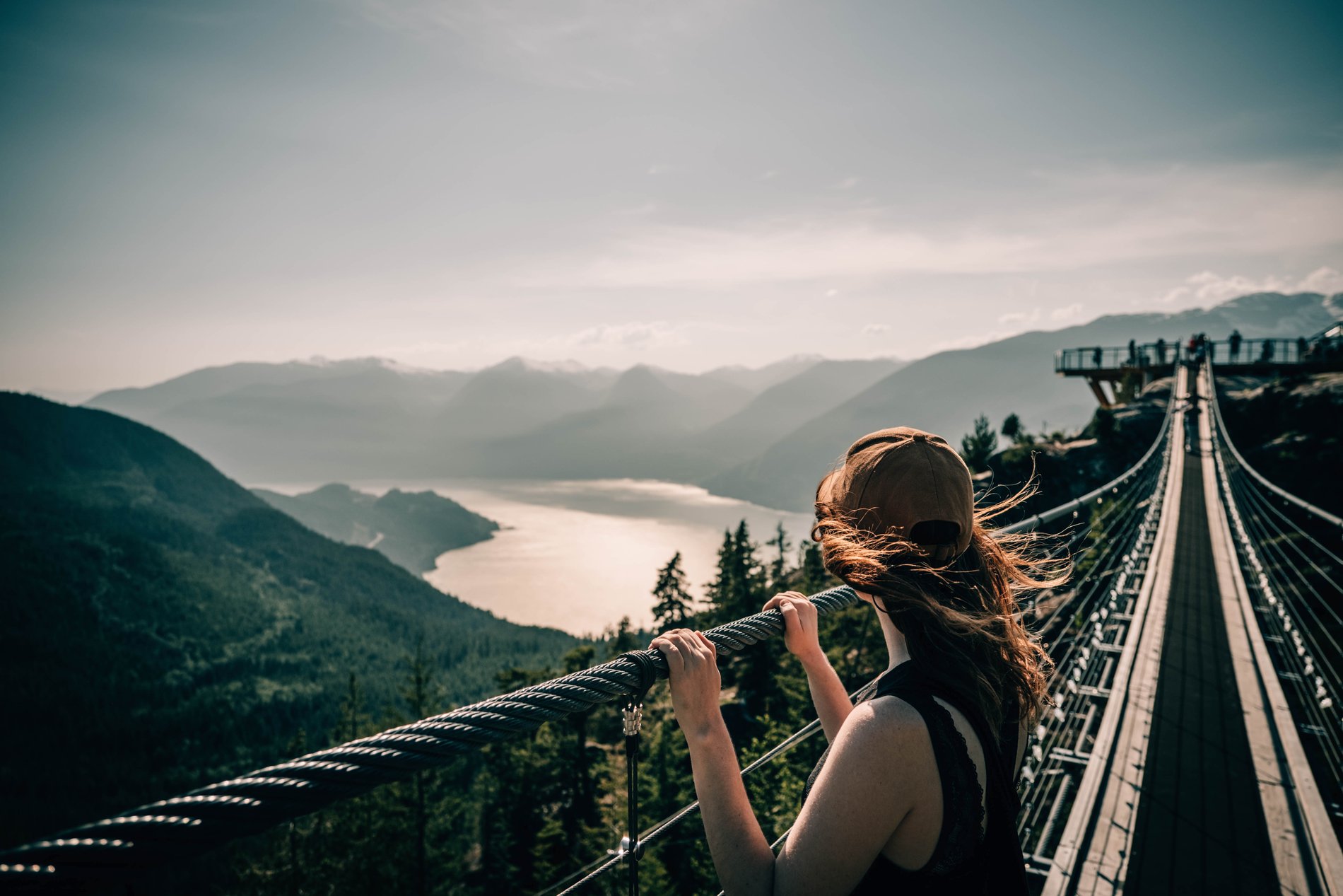 Person viewing Howe Sound from the Sky Pilot Suspension Bridge at the Sea to Sky Gondola in Squamish.