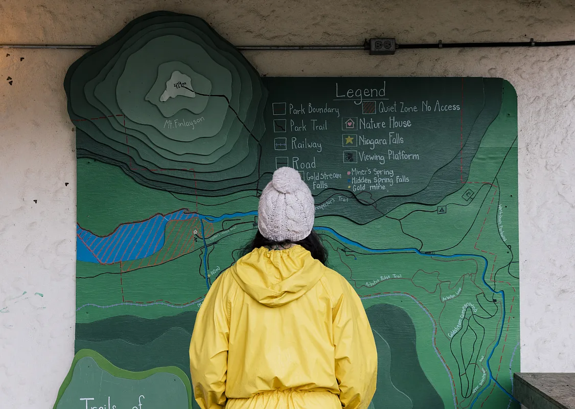 Eine Person betrachtet die Wanderkarte im Goldstream Provincial Park