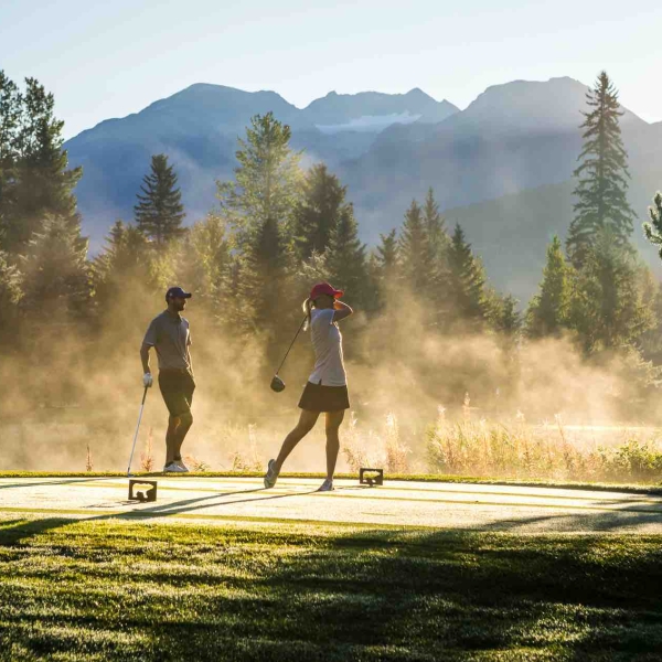 Two golfers tee off in then early morning at Nicklaus North Golf Course. The morning dew is burning off in the sun.