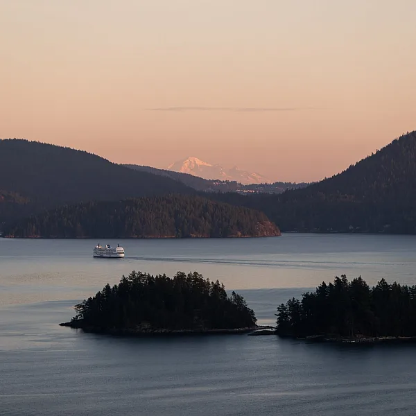 Vista aérea de un BC Ferry navegando junto a dos pequeñas islas al atardecer