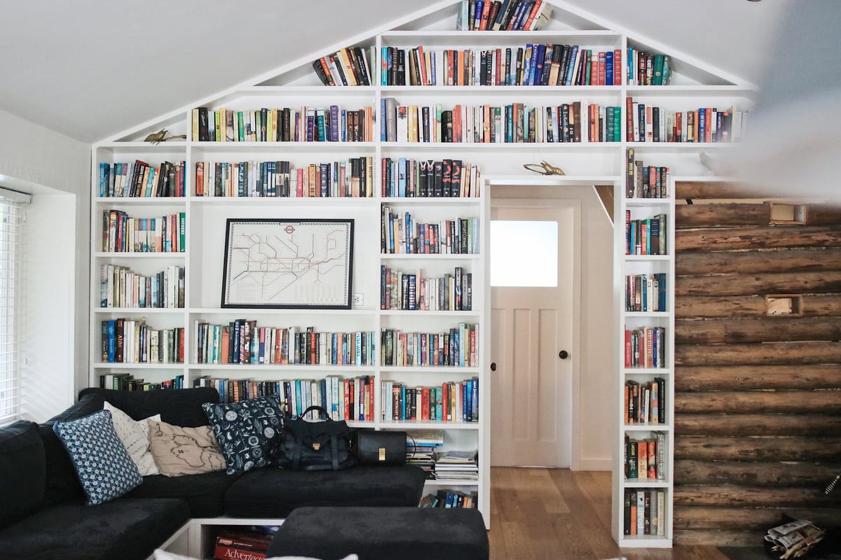 A cabin with a bookshelf wall at the Sunwolf Cabins. A couch with throw pillows in front.