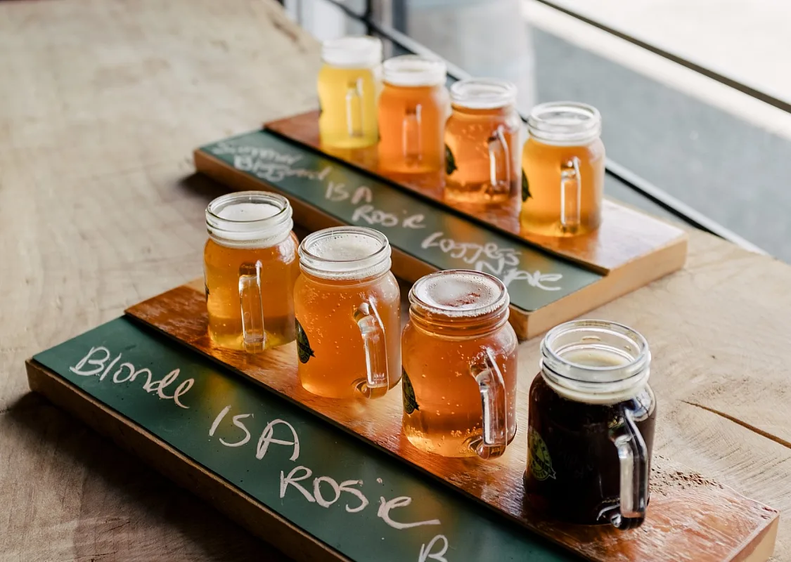 Two flights of beer with four small beers on wooden planks, placed on a table at Jackson's Social Club & Brewhouse in 100 Mile House