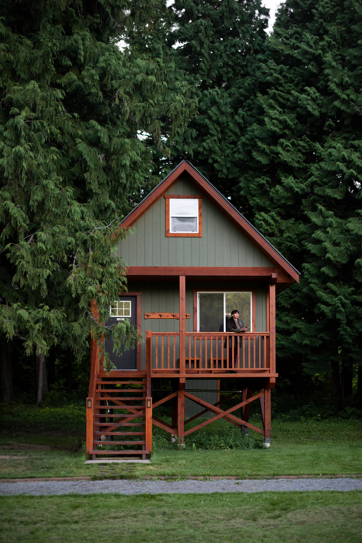 A green cabin with food frame in the forest at Hidden Acres Treehouse Resort