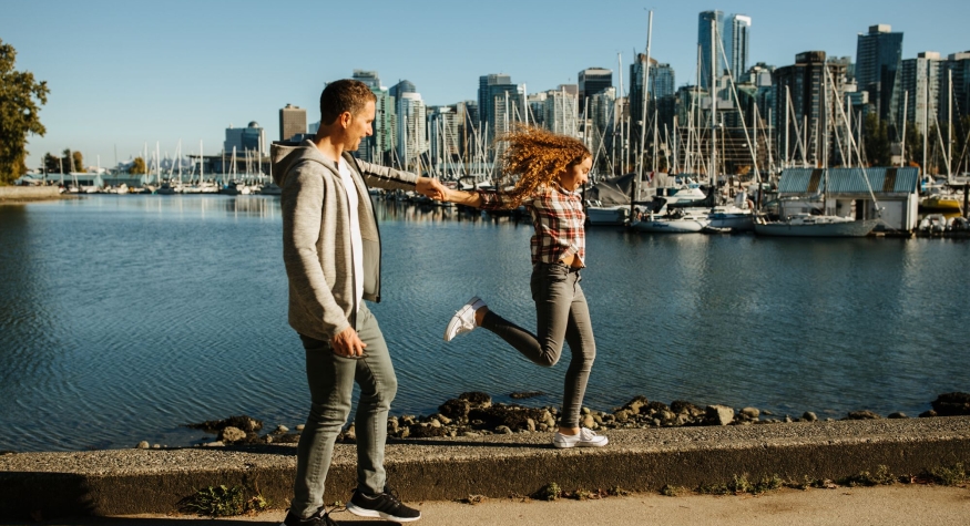 Vater und Tochter spazieren auf der Uferpromenade in Coal Harbour | Destination Vancouver/Hubert Kang