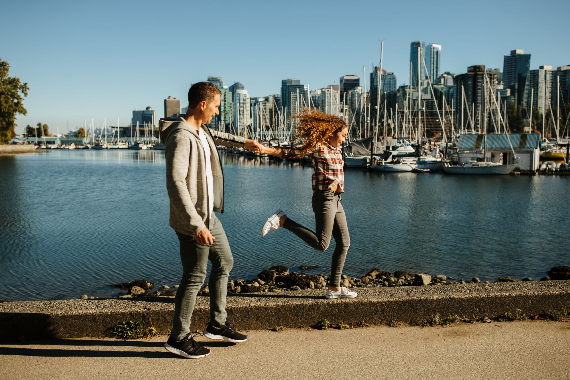 Dad and daughter walking on seawall at Coal Harbour | Destination Vancouver/Hubert Kang