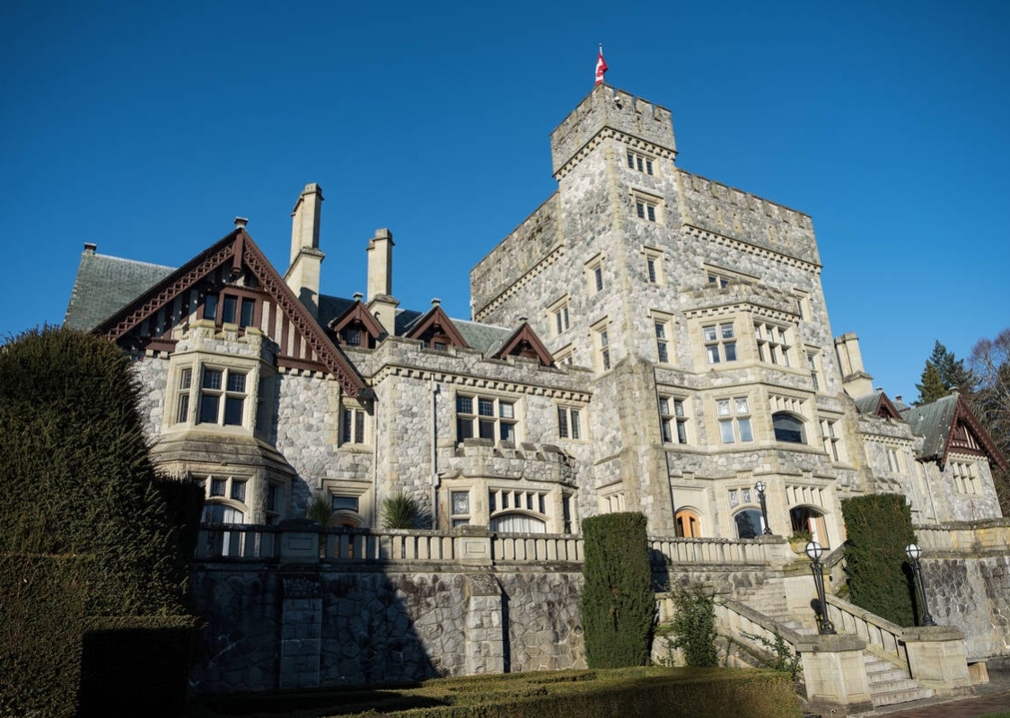 Der Blick vom Boden auf das stattliche Schloss Hatley vor einem strahlend blauen Himmel