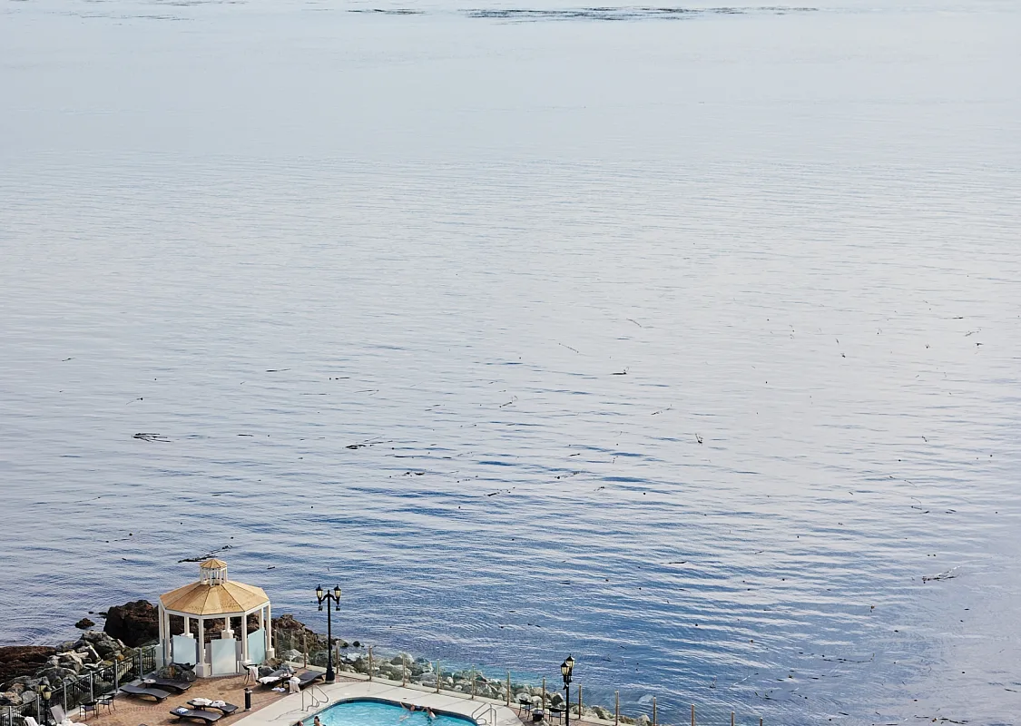A aerial view of the hot tub and pools at the Oak Bay Beach Hotel as they look out onto the ocean in front.