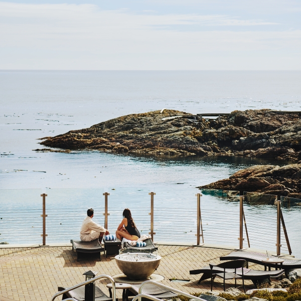 Two people look out at the ocean during the day at Oak Bay Beach Hotel