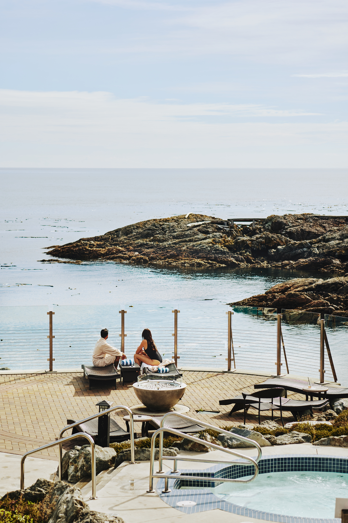 Two people look out at the ocean during the day at Oak Bay Beach Hotel