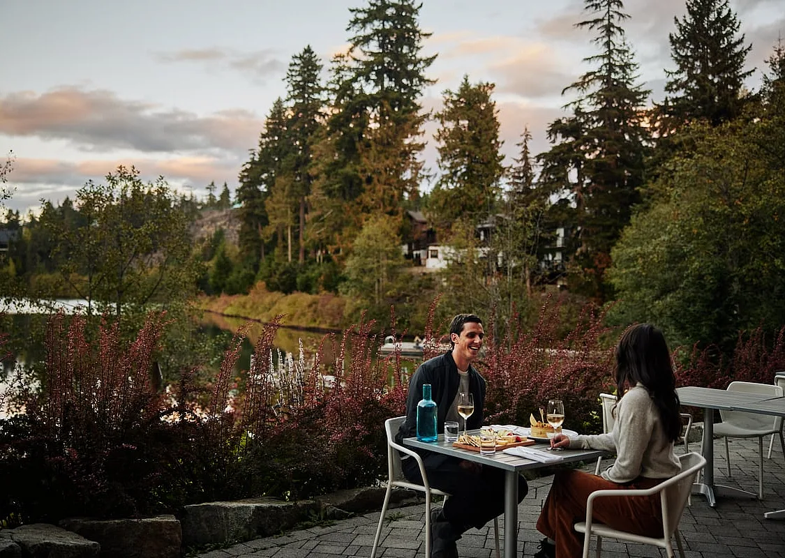 Zwei Personen essen auf einer Terrasse der Nita Lake Lodge