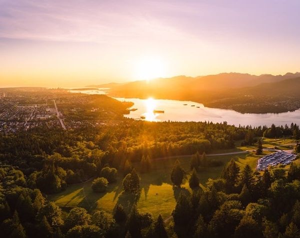 Eine Sonnenuntergangs-Aussicht vom Burnaby Mountain, mit Blick auf Baumwipfel, die sich bis zum Horizont erstrecken.