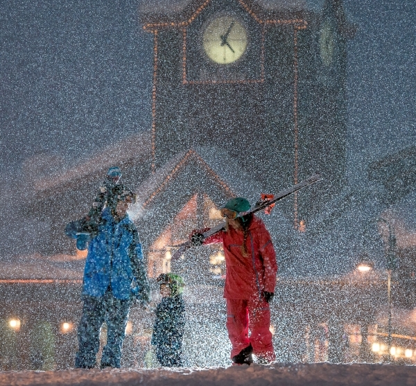 Familia caminando con sus esquís en la nieve